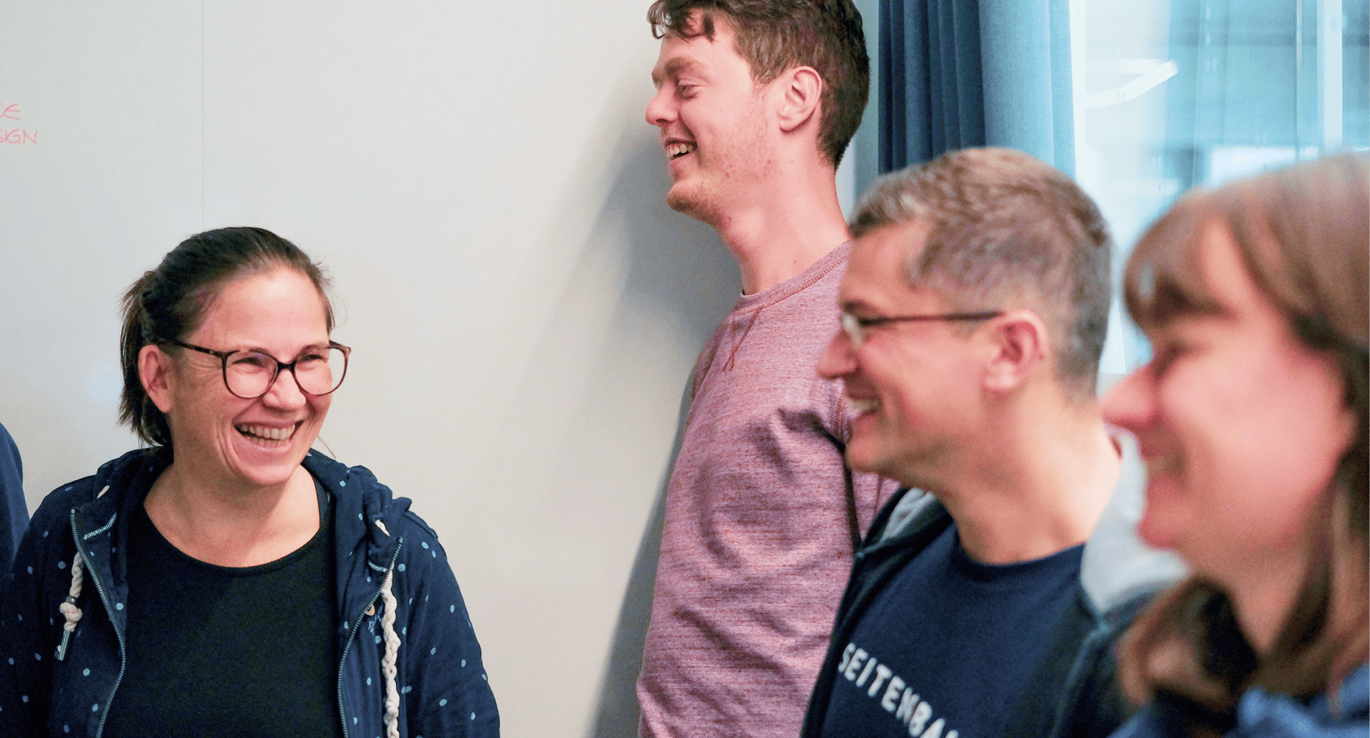 Eine Gruppe von lachenden Mitarbeitenden