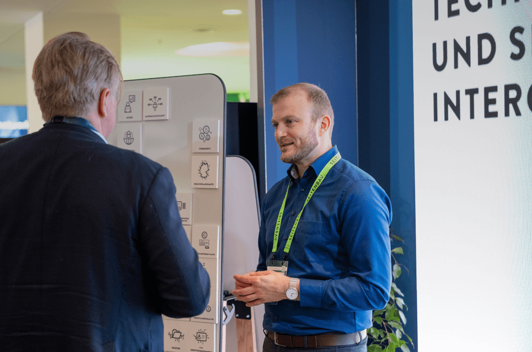 Mehrere Personen stehen am Messestand und unterhalten sich