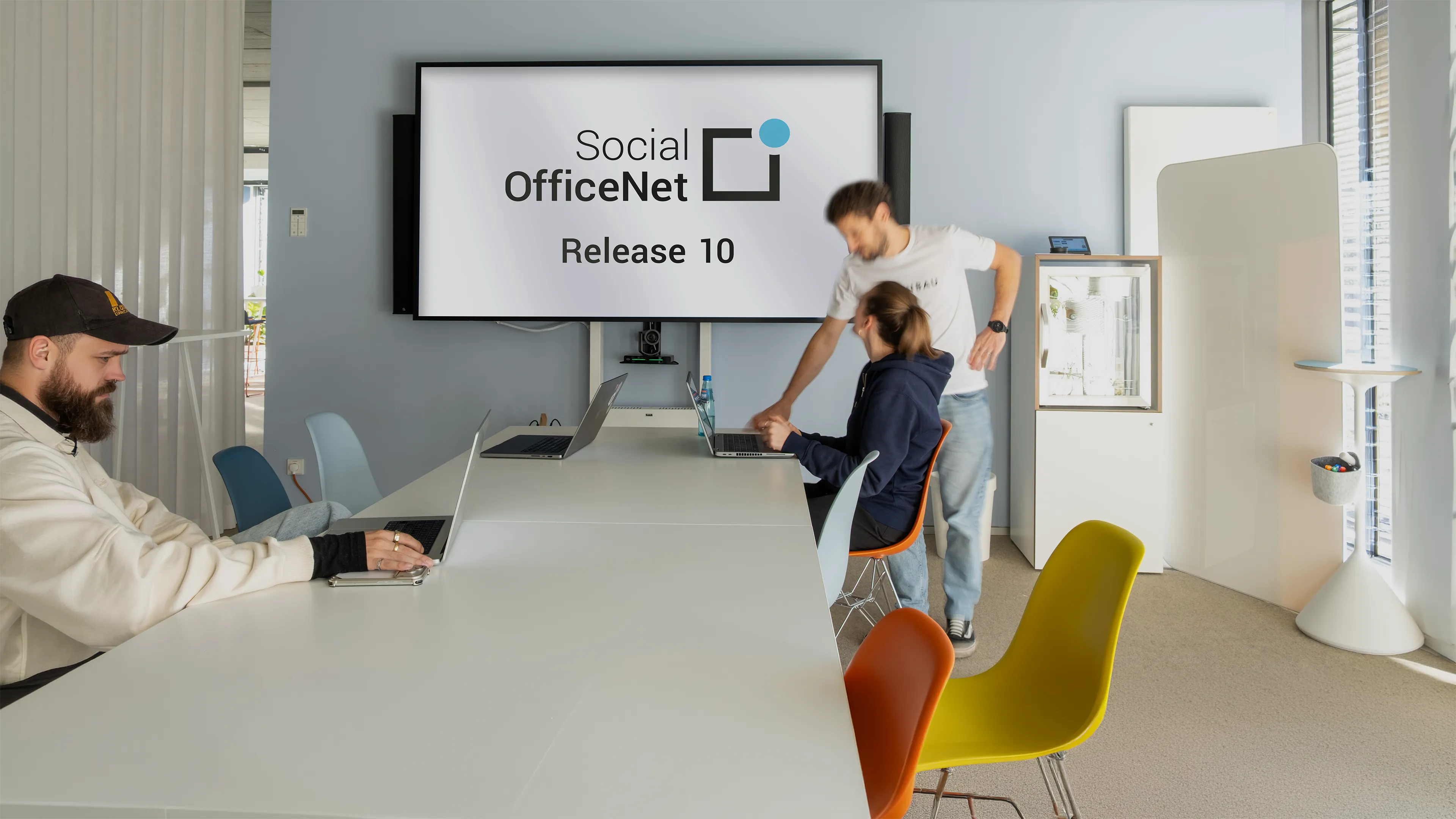 2 Personen vor einem Bildschirm auf dem der Text steht: "Social OfficeNet Release 10"