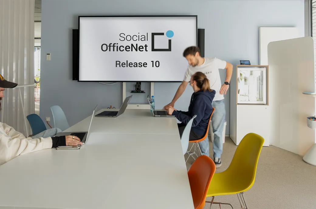 2 Personen vor einem Bildschirm auf dem der Text steht: "Social OfficeNet Release 10"
