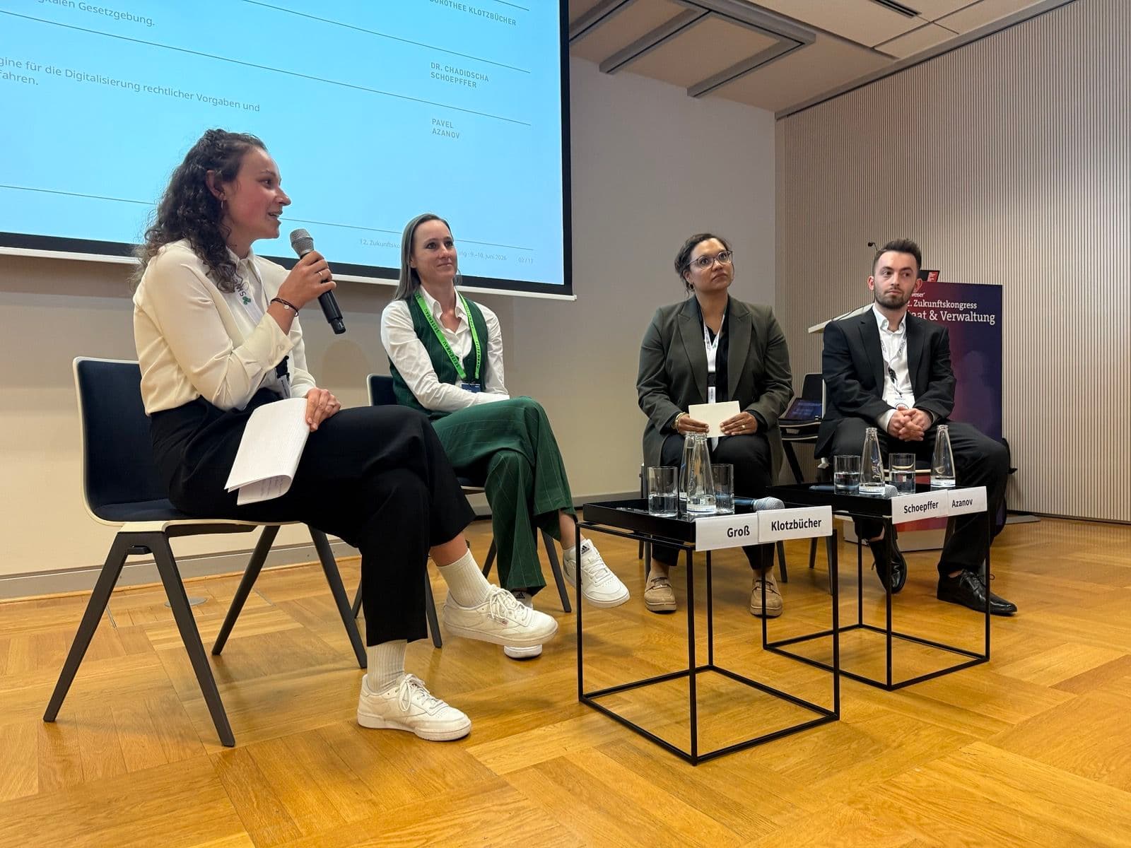 Vier Menschen sitzen auf der Bühne eines Panels beim Zukunftskongress 2026