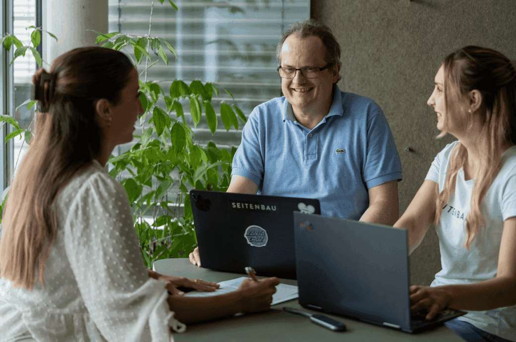 Zwei HR-Kolleginnen im Beratungsgespräch mit einem älteren SEITENBAU-Kollegen