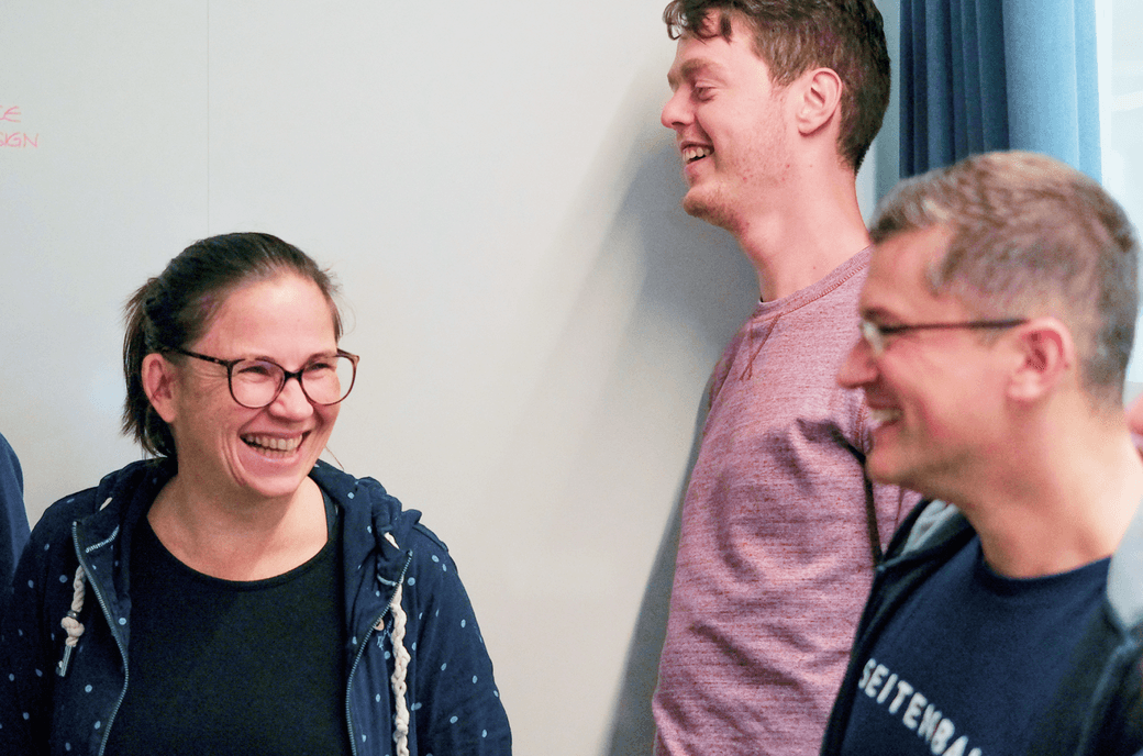 Eine Gruppe von lachenden Mitarbeitenden