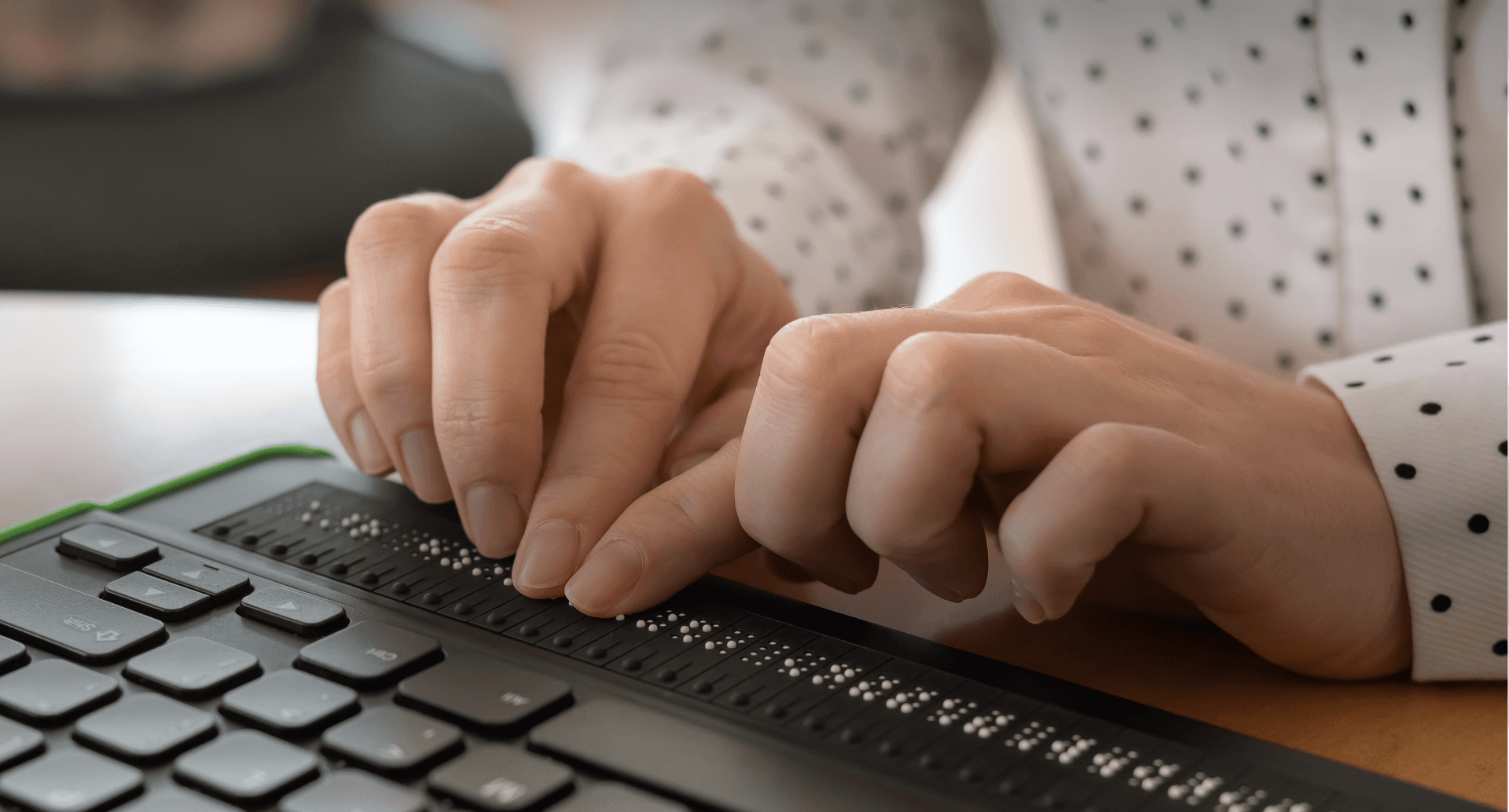Zwei Hände die an einer Braille-Tastatur tippen am Computer