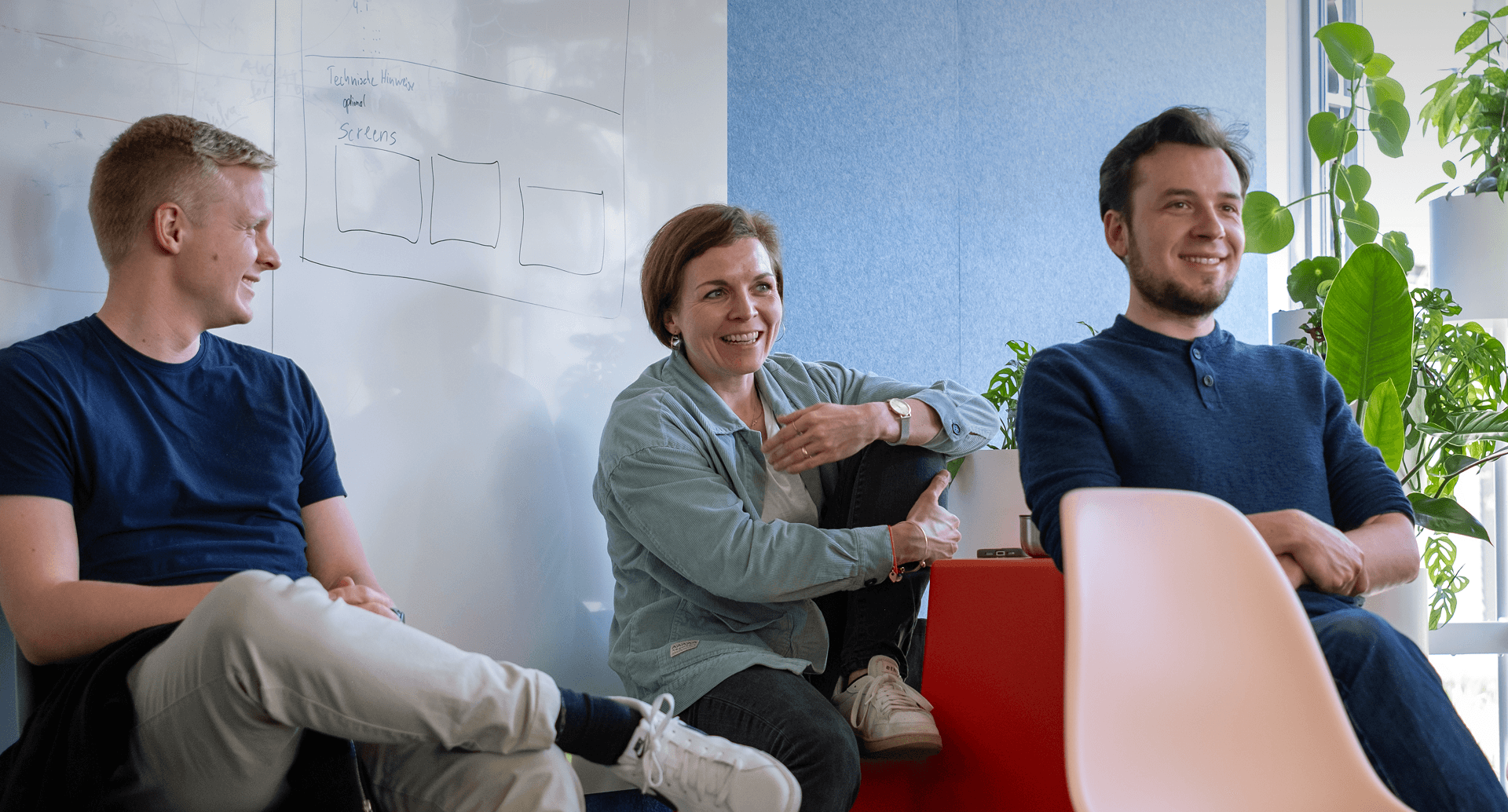 Eine Gruppe von Mitarbeitenden sitzt im Kreis und lacht