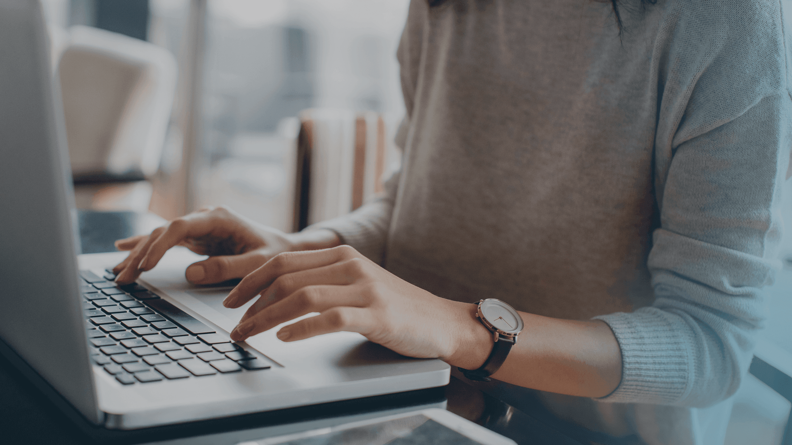 mitarbeitende person schreibt am laptop