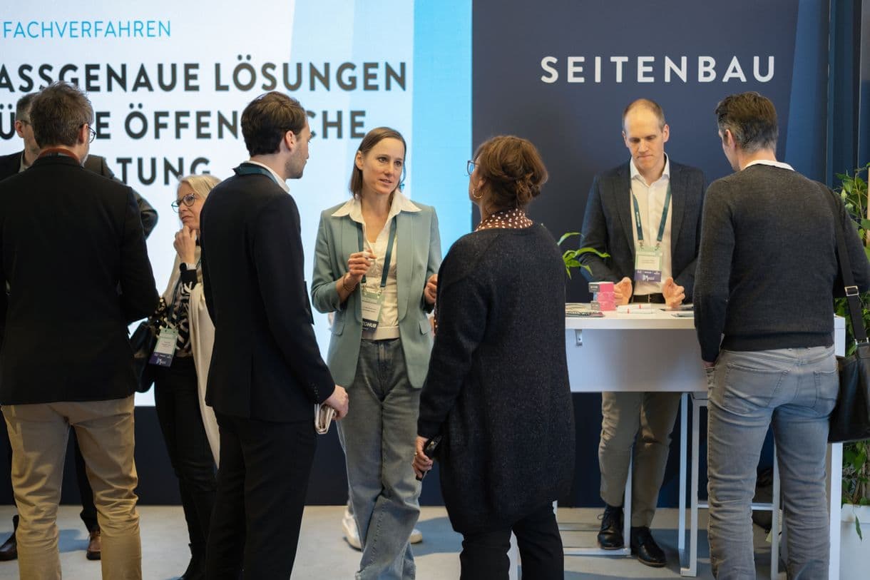 Der Stand von SEITENBAU beim Digitalen Staat 2025. Mehrere Menschen sind im Gespräch miteinander.